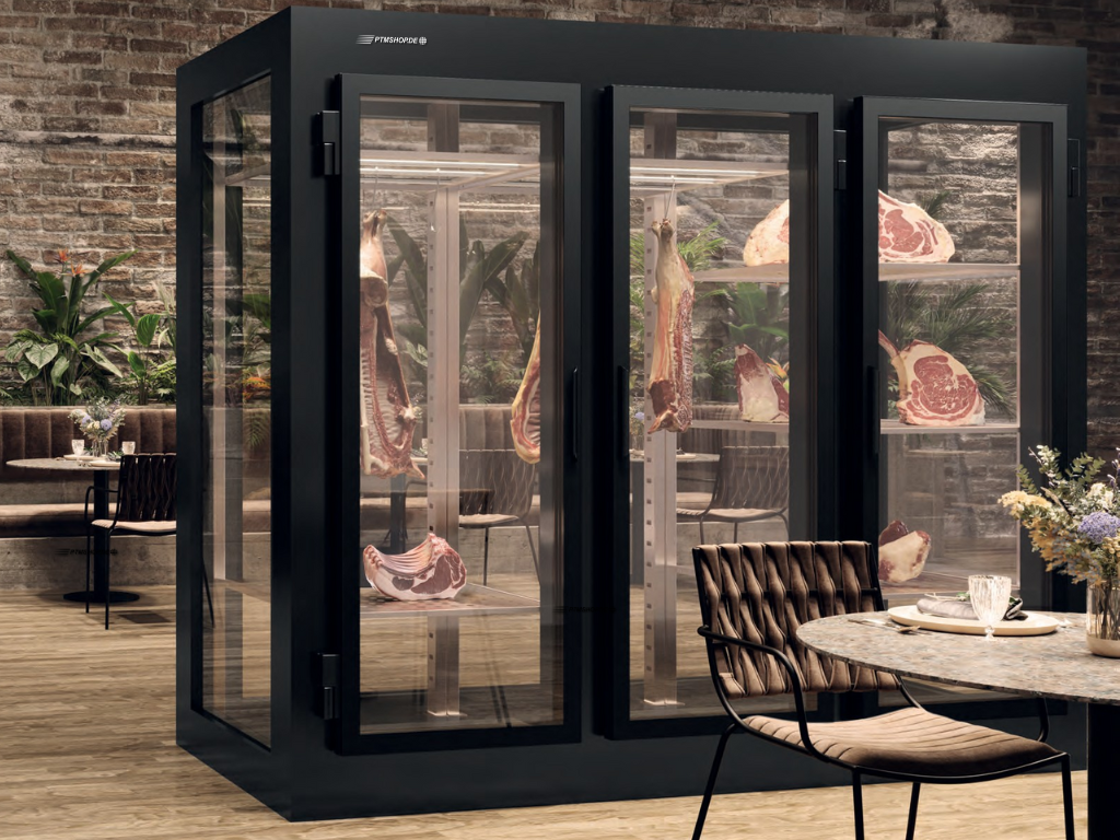 Eleganter Dry Ager Reifeschrank mit Glasfront und hängendem Fleisch in einem modernen Restaurantambiente – Premiumausstattung erhältlich bei PTMshop.de.